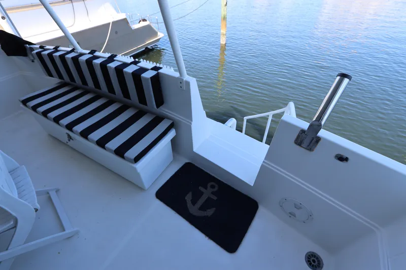 Slide: The Image of 1991 Viking Motor Yacht deck with striped seating and anchor-themed mat. - 19