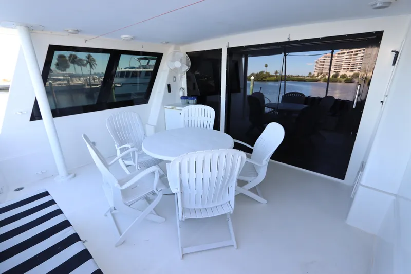 Slide: The Image of Outdoor seating area on a 1991 Viking Motor Yacht with white chairs and table. - 21