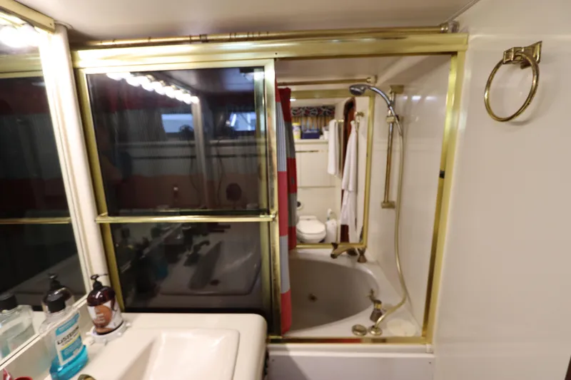 Slide: The Image of Bathroom in a 1991 Viking Motor Yacht with gold fixtures and a shower-tub combo. - 33