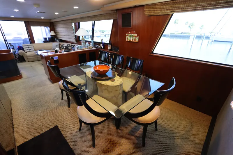 Slide: The Image of Luxurious interior of a 1991 Viking Motor Yacht with a glass dining table and seating. - 38