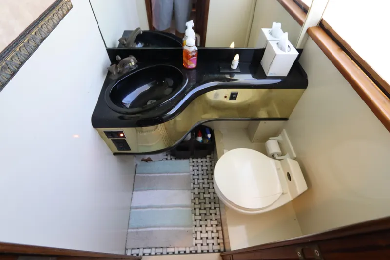 Slide: The Image of Compact bathroom in a 1991 Viking Motor Yacht with black sink and modern fixtures. - 40