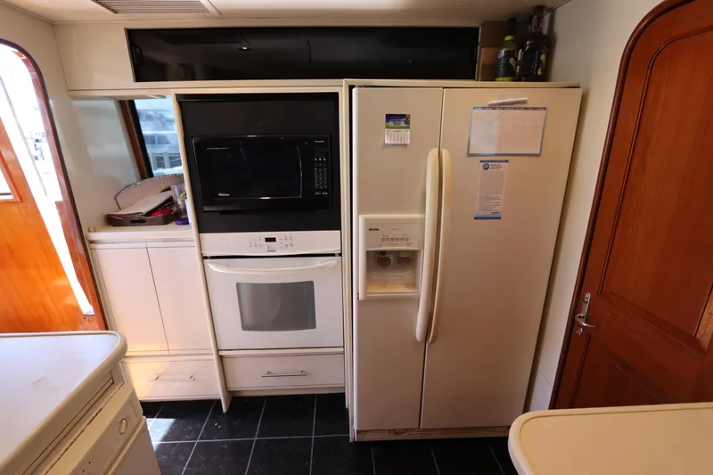 Slide: The Image of 1991 Viking Motor Yacht kitchen with refrigerator, oven, and microwave. - 46