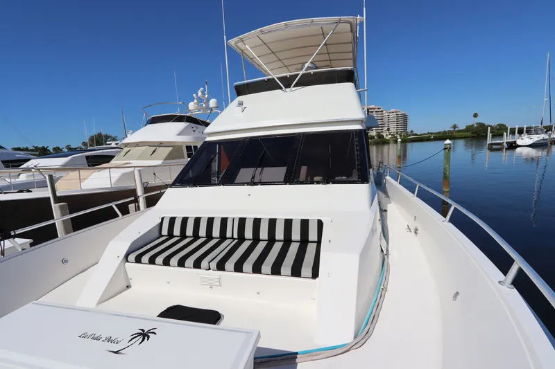 Slide: The Image of 1991 Viking Motor Yacht with striped seating, docked in a marina under clear blue skies. - 8
