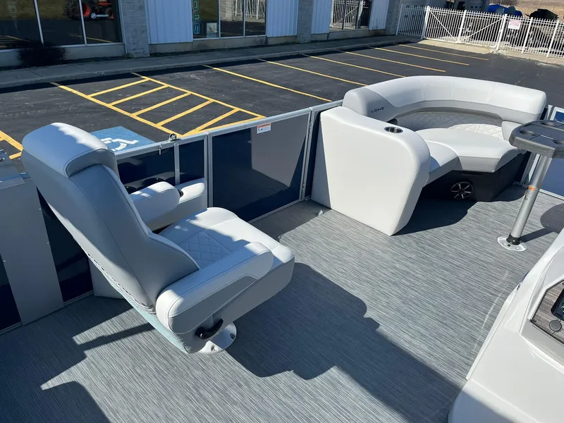 Slide: The Image of 2024 Lowe SS 210 DL pontoon boat interior with plush seating and modern design. - 10