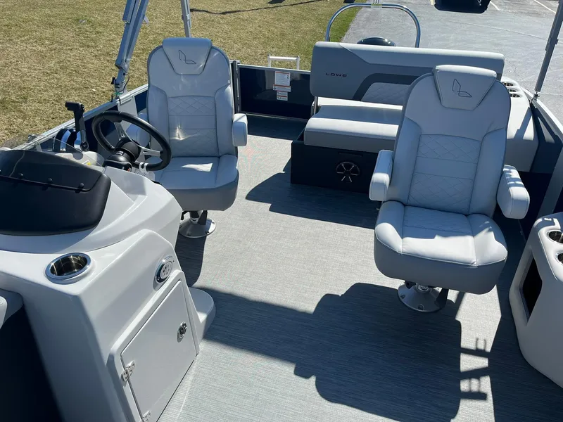 Slide: The Image of 2024 Lowe SS 210 DL pontoon boat interior with captain chairs and console. - 11