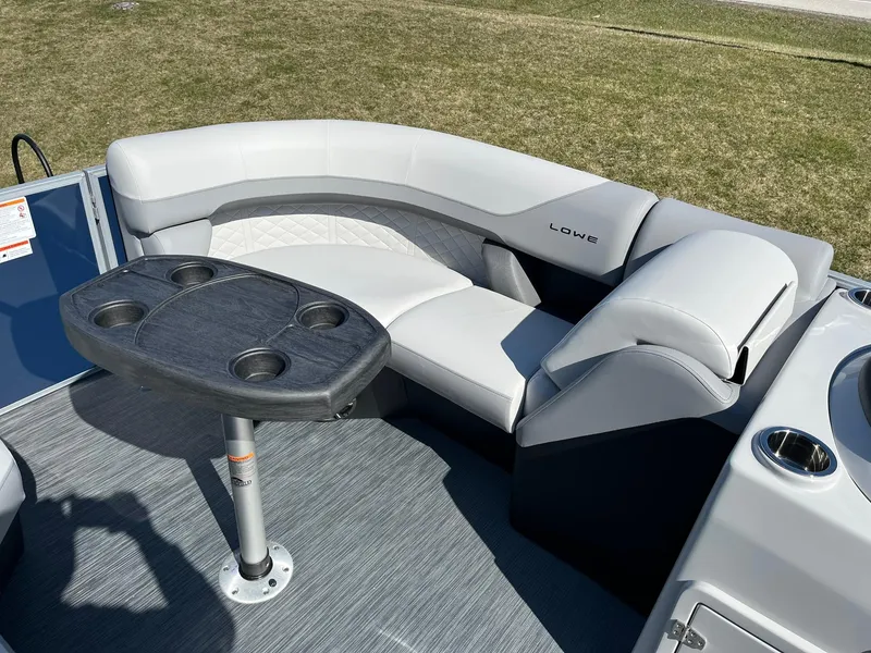 Slide: The Image of 2024 Lowe SS 210 DL pontoon boat with cushioned seating and a table. - 20
