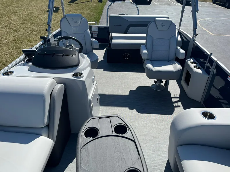 Slide: The Image of 2024 Lowe SS 210 DL pontoon boat interior with plush seating and modern helm. - 5