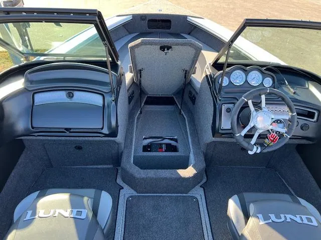 Slide: The Image of 2024 Lund 1875 Crossover XS boat interior with open windshield and steering console. - 7