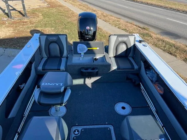 Slide: The Image of 2024 Lund 1875 Crossover XS boat interior with seating and motor. - 8