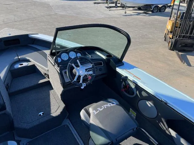 Slide: The Image of 2024 Lund 1875 Crossover XS boat interior with steering console and seating. - 9