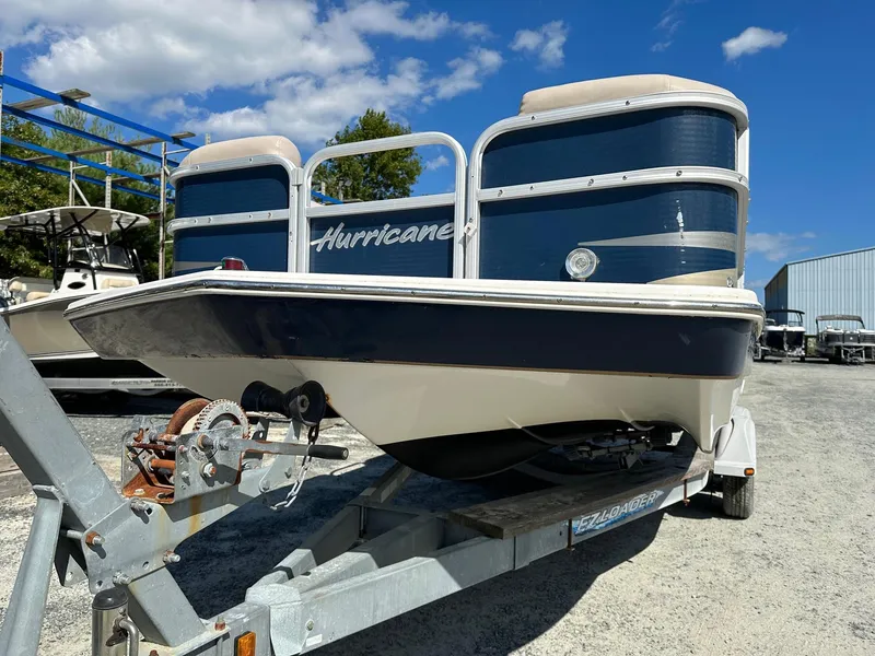 Slide: The Image of 2014 Godfrey Hurricane boat on a trailer under a clear blue sky. - 2