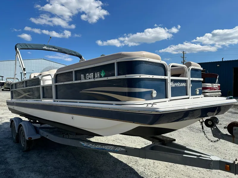 Slide: The Image of 2014 Godfrey Hurricane pontoon boat on a trailer under a clear blue sky. - 3