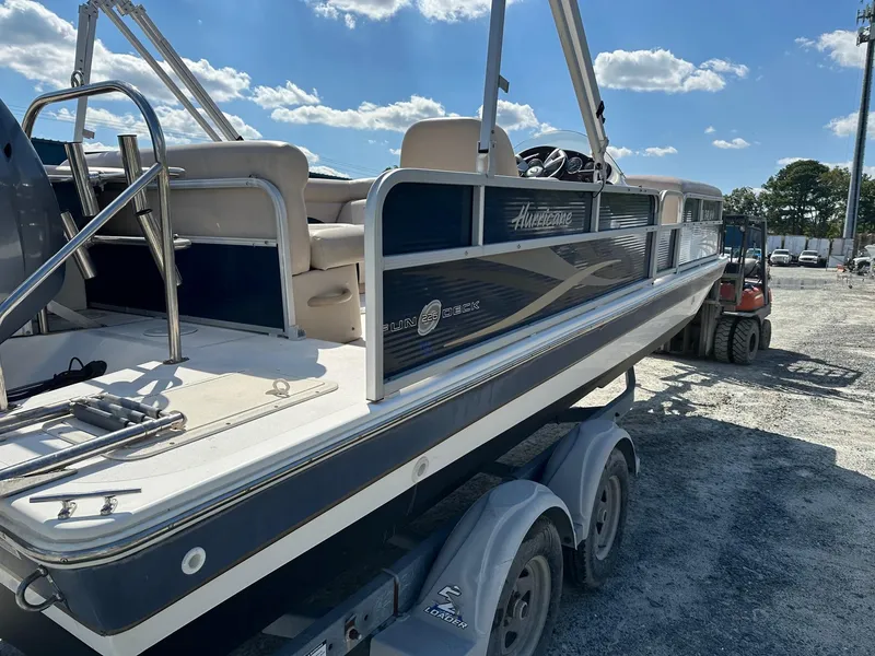 Slide: The Image of 2014 Godfrey Hurricane boat on a trailer under a clear blue sky. - 4