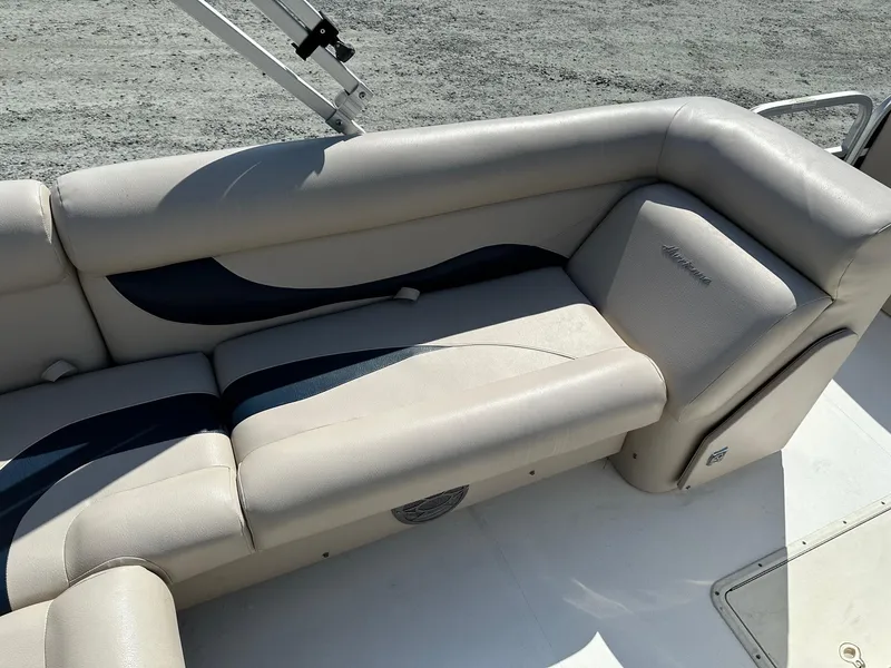 Slide: The Image of 2014 Godfrey Hurricane boat interior with beige and blue cushioned seating. - 7