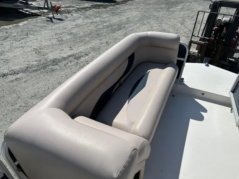 Slide: The Image of 2014 Godfrey Hurricane boat with beige seating on a sunny day. - 8