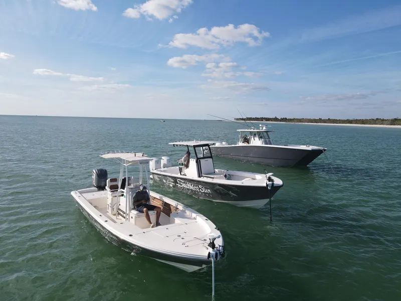 Slide: The Image of 2014 Pathfinder 2600 HPS boat on calm water with two other boats nearby. - 2