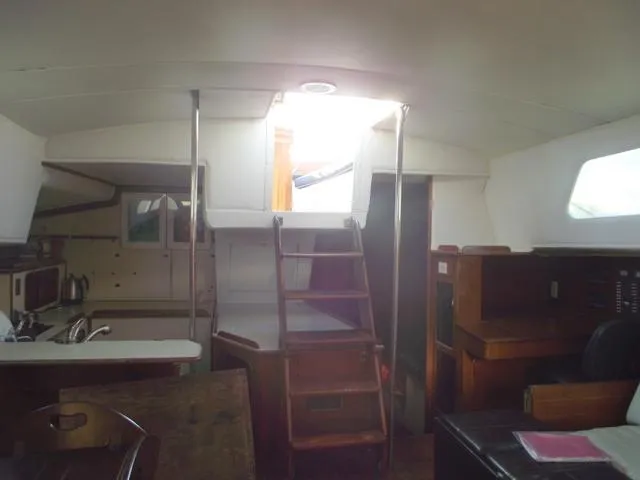 Slide: The Image of Interior of 1984 Irwin Center Cockpit sailboat, featuring kitchen and wooden ladder to deck. - 17