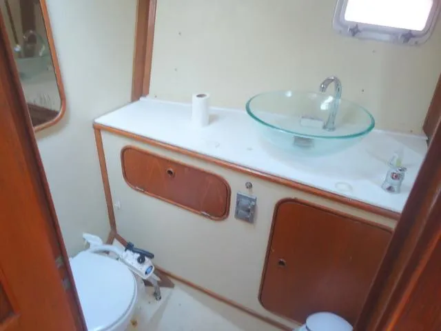 Slide: The Image of 1984 Irwin Center Cockpit bathroom with glass sink and wooden cabinetry. - 28