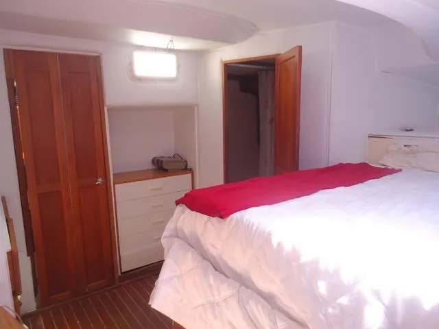 Slide: The Image of 1984 Irwin Center Cockpit interior with cozy bedroom, wooden doors, and white bedding. - 29