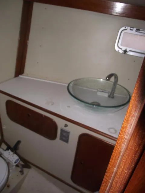 Slide: The Image of 1984 Irwin Center Cockpit bathroom with glass sink and wooden cabinetry. - 33