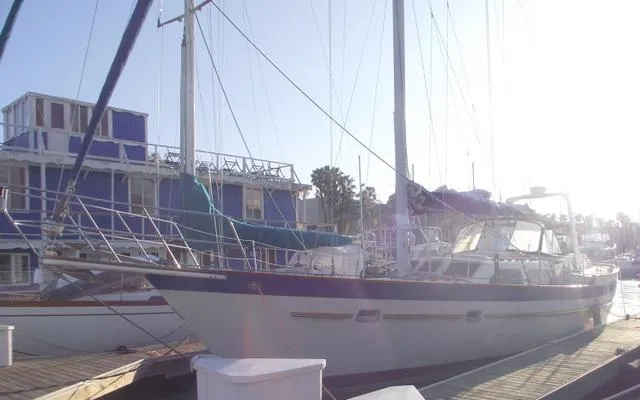 Slide: The Image of 1984 Irwin Center Cockpit sailboat docked at a marina with blue buildings. - 4