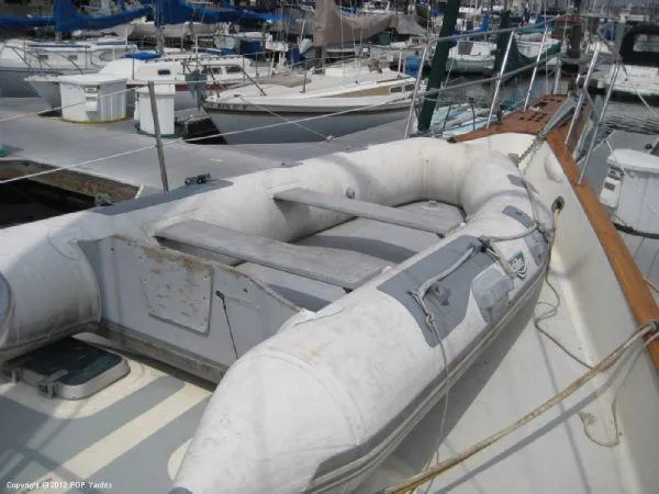 Slide: The Image of 1984 Irwin Center Cockpit sailboat with inflatable dinghy on deck, docked at marina. - 9