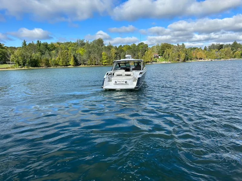 Slide: The Image of 2015 Cobalt A40 boat cruising on a scenic lake with a forested shoreline. - 15
