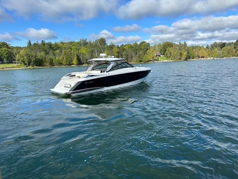 Slide: The Image of 2015 Cobalt A40 boat cruising on a lake with a forested shoreline. - 17