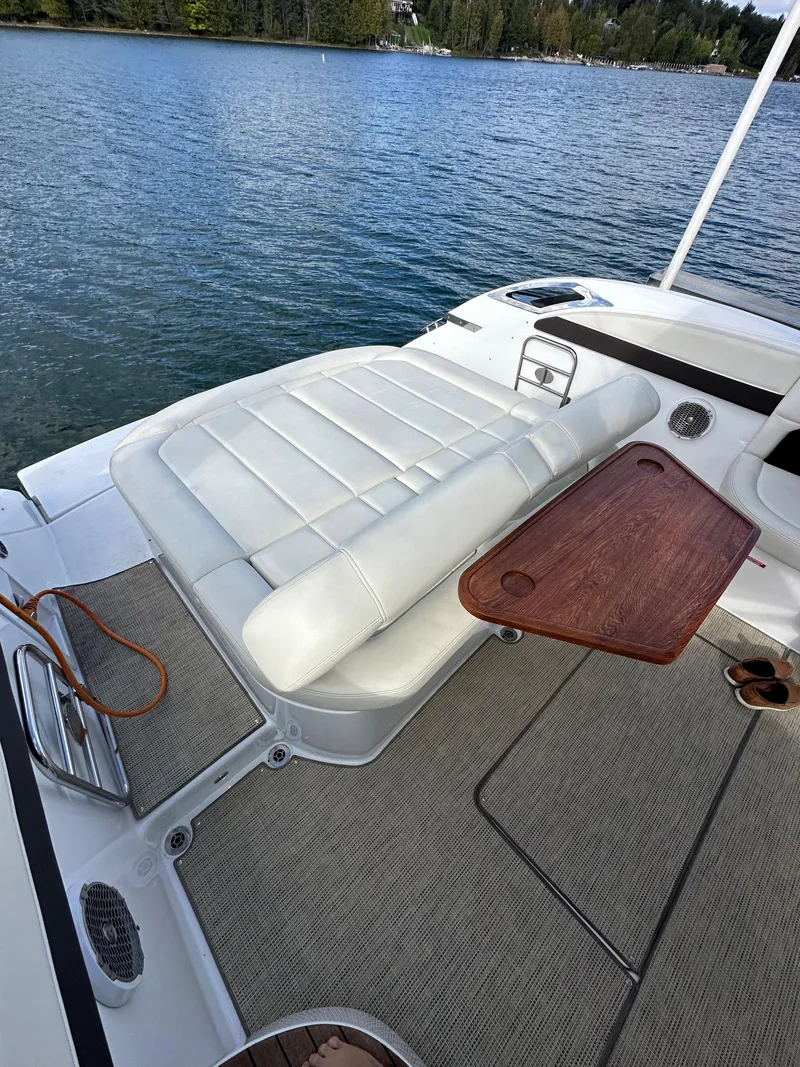 Slide: The Image of 2015 Cobalt A40 boat with white seating and wooden table on a lake. - 18