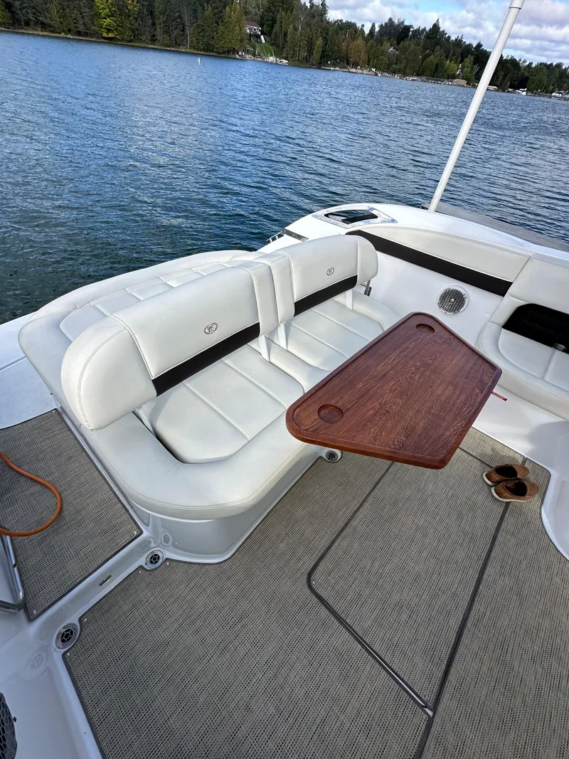 Slide: The Image of 2015 Cobalt A40 boat with white seating and wooden table on a lake. - 19