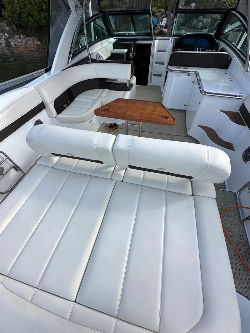Slide: The Image of 2015 Cobalt A40 boat interior with white leather seating and wooden table. - 20