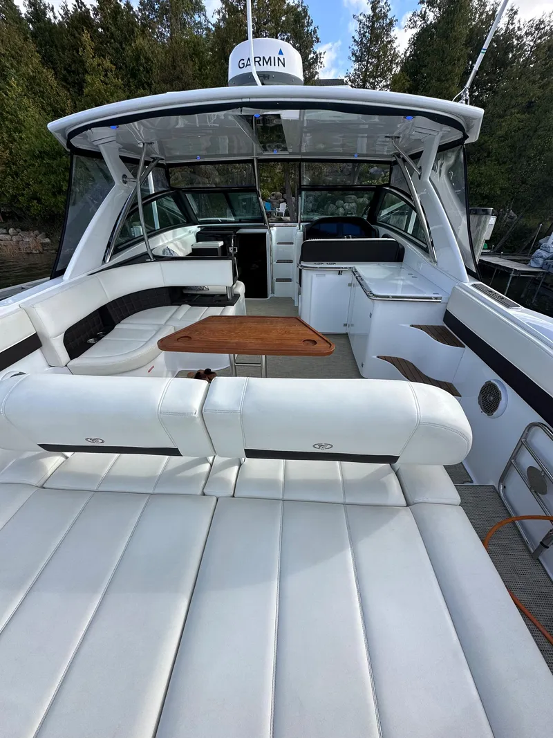 Slide: The Image of 2015 Cobalt A40 boat with white leather seating and wooden table. - 21