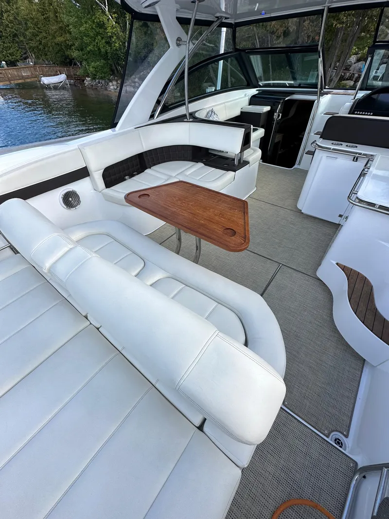 Slide: The Image of Luxurious interior of a 2015 Cobalt A40 boat with white seating and wooden table. - 23