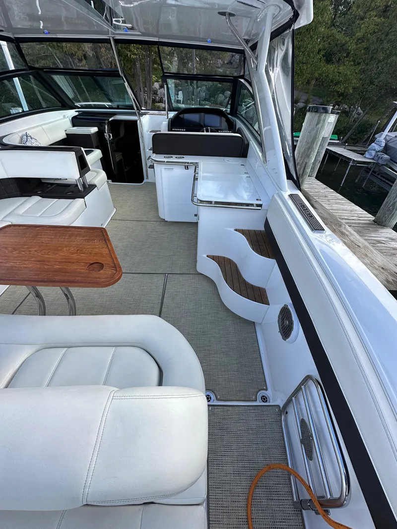 Slide: The Image of 2015 Cobalt A40 boat interior with white seating and wooden table. - 24