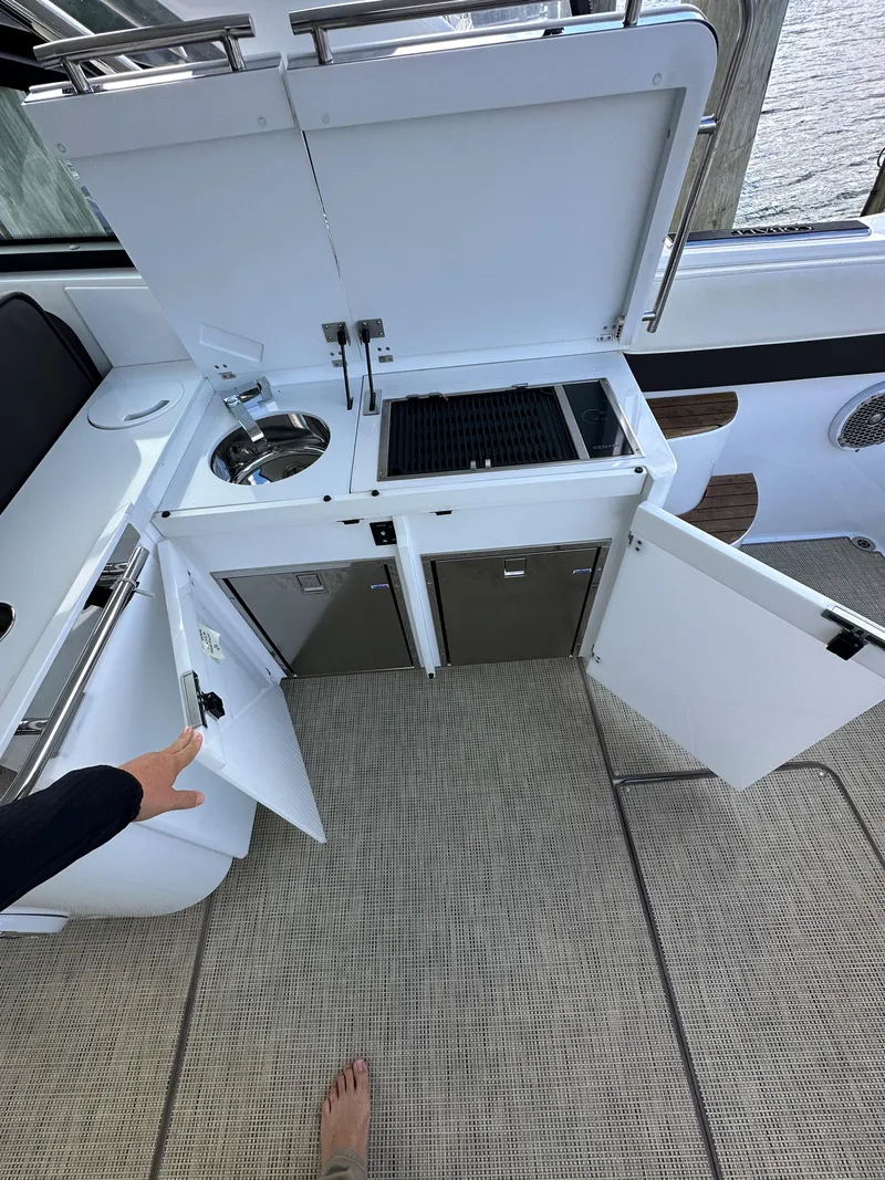 Slide: The Image of Outdoor kitchen setup on a 2015 Cobalt A40 boat with sink and grill. - 25