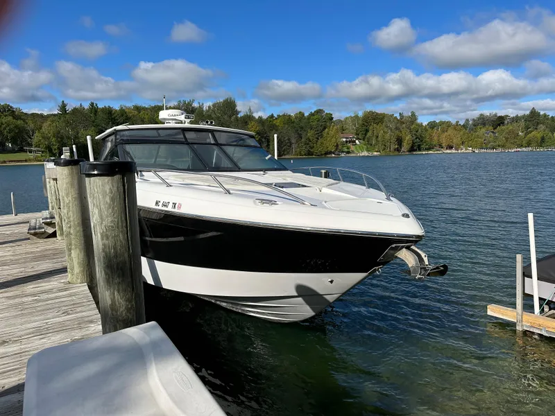 Slide: The Image of 2015 Cobalt A40 boat docked on a serene lake with a wooded shoreline. - 45