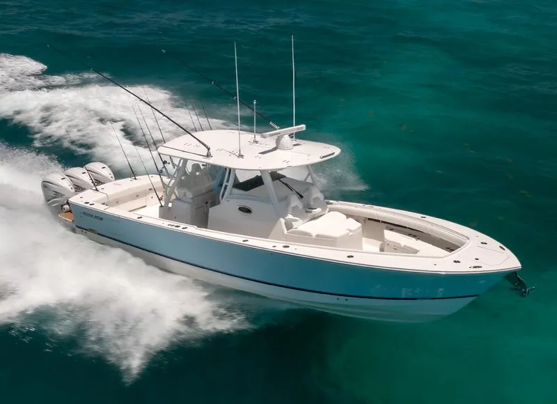 Slide: The Image of 2025 Regulator 37 boat cruising on clear turquoise waters. - 18