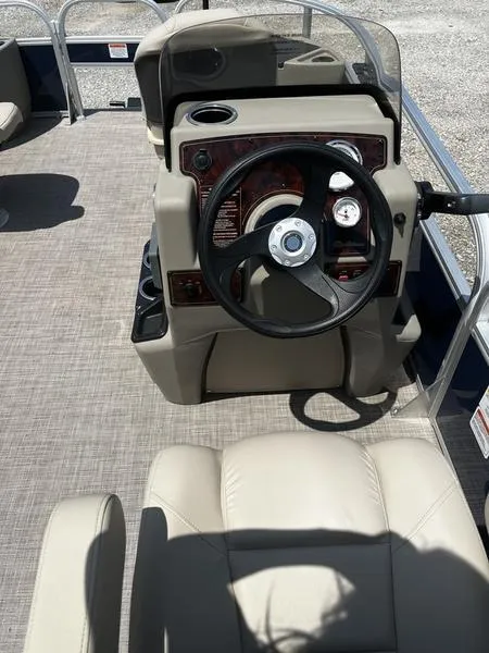 Slide: The Image of 2024 Sun Tracker Bass Buggy 18 DLX boat console with steering wheel and gauges. - 2