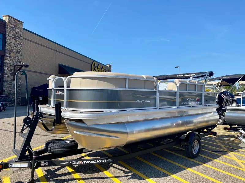 The Image of 2024 Sun Tracker Party Barge 18 DLX pontoon boat on trailer outside Cabela's. - 0
