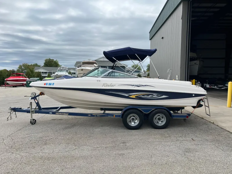 The Image of 2002 Rinker 212 Captiva Bowrider on trailer, parked outside a storage facility. - 0