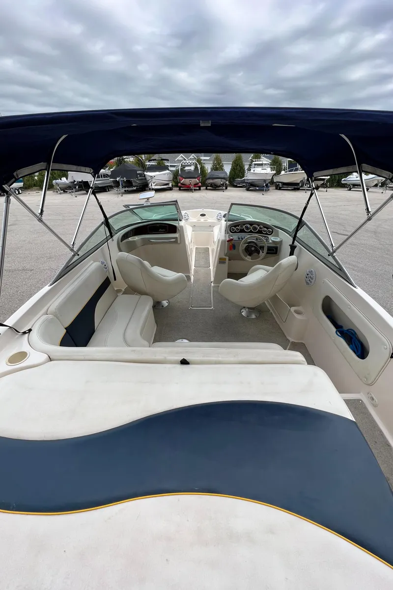 Slide: The Image of 2002 Rinker 212 Captiva Bowrider with blue canopy and white interior. - 11