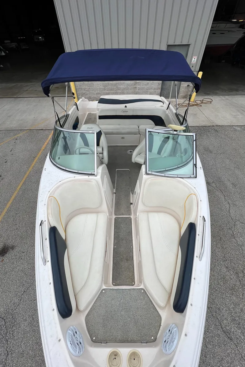 Slide: The Image of 2002 Rinker 212 Captiva Bowrider with blue canopy and white seating. - 2