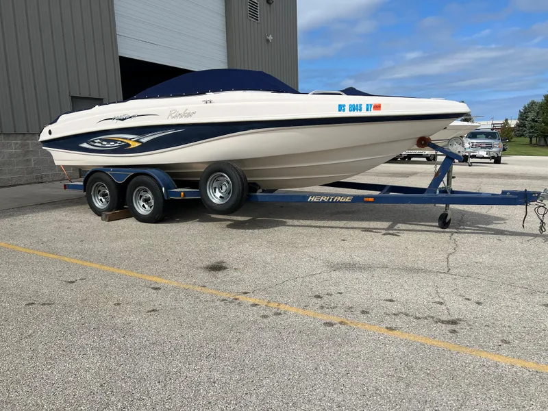 Slide: The Image of 2002 Rinker 212 Captiva Bowrider on a trailer in a parking lot. - 7