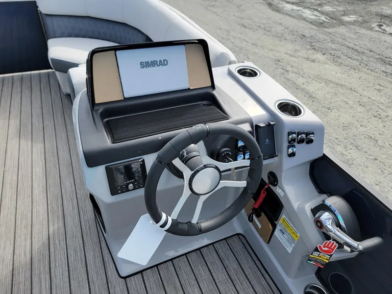 Slide: The Image of 2024 Harris Sunliner 230 Sport boat helm with Simrad display and modern controls. - 13