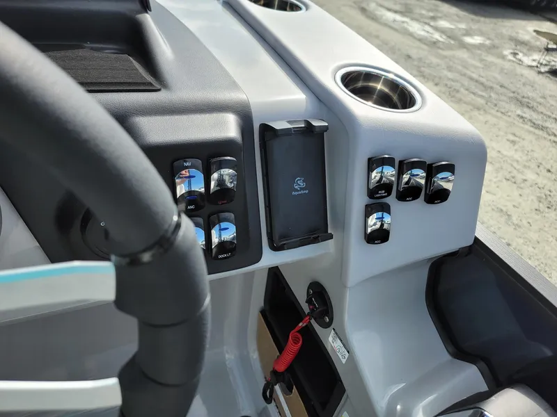 Slide: The Image of Control panel of 2024 Harris Sunliner 230 Sport boat with cup holders and switches. - 16
