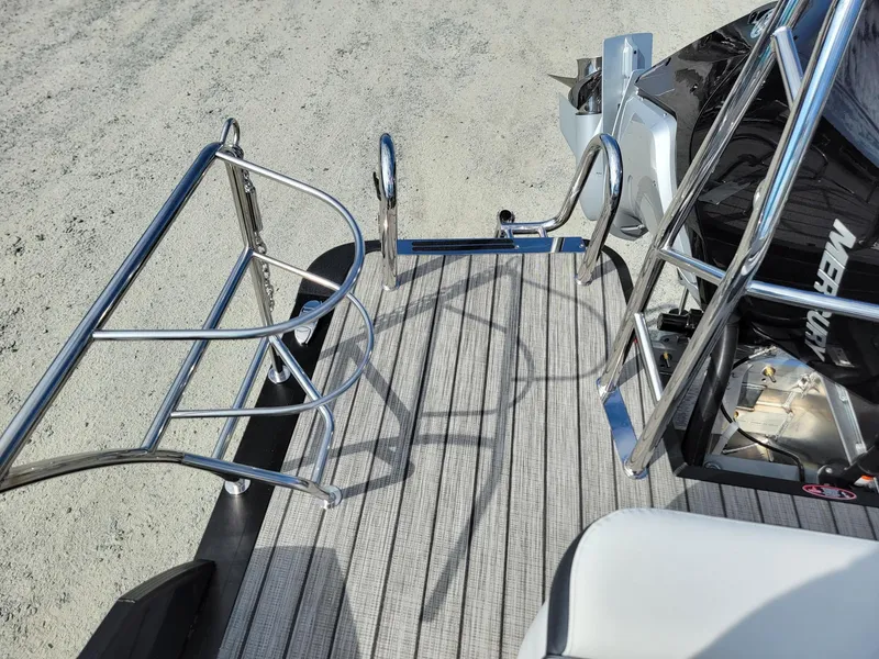 Slide: The Image of 2024 Harris Sunliner 230 Sport boat deck with stainless steel railings and outboard motor. - 22