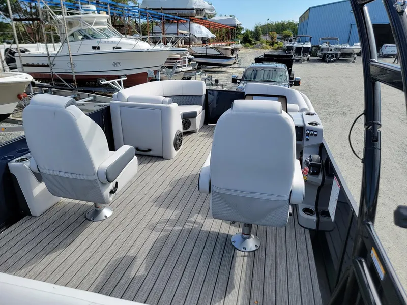 Slide: The Image of 2024 Harris Sunliner 230 Sport boat interior with seating and control console. - 24