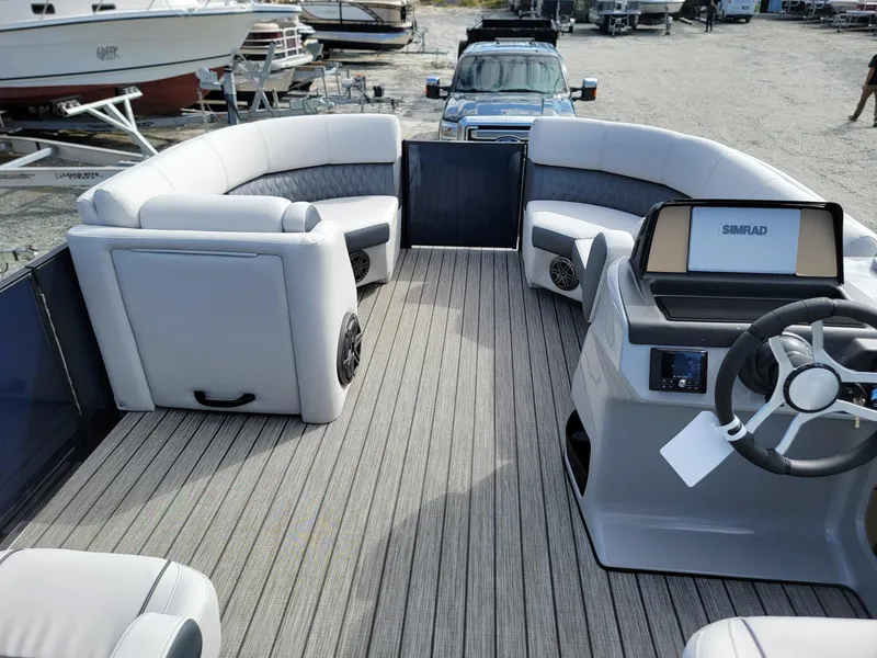 Slide: The Image of 2024 Harris Sunliner 230 Sport pontoon boat interior with plush seating and modern helm. - 25