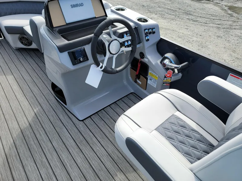 Slide: The Image of 2024 Harris Sunliner 230 Sport boat interior with steering wheel and captain's chair. - 27