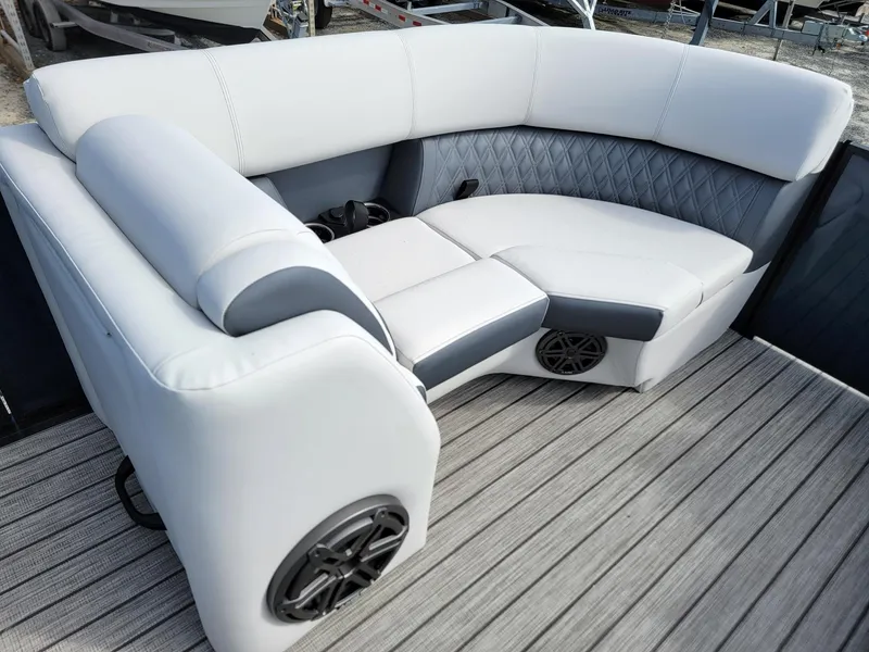 Slide: The Image of 2024 Harris Sunliner 230 Sport boat interior with luxurious seating and built-in speakers. - 30